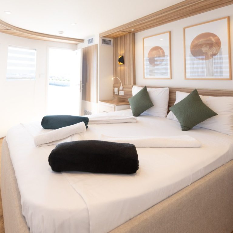 Helles Schlafzimmer mit großen Fenstern, dekorierten Wänden und gemütlichen Decken.
