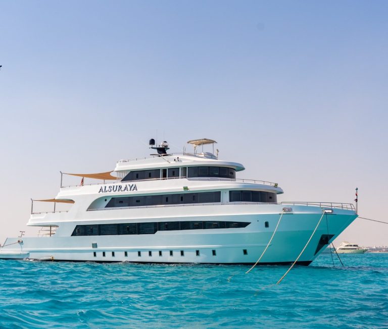 Luxuriöser Superyacht in turquoise Wasser, sonniger Himmel im Hintergrund.