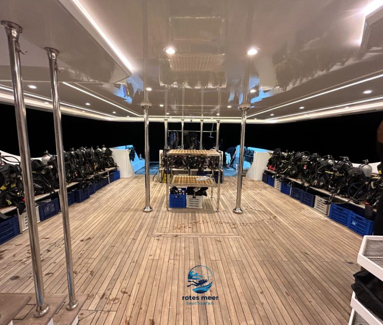 Ein Bootsdeck mit mehreren Tauchgeräten und einem zentralen Steuertisch.